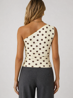 Back view of a cream polka dot one shoulder top showing the asymmetric shoulder line