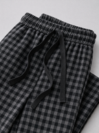 Close up of the elastic drawstring waistband and check fabric on black wide leg pants