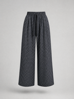 Black check wide leg pants shown on their own against a light grey background