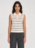 Woman wearing a cream striped sleeveless knit polo top, front view on a light grey studio background