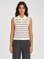 Woman wearing a cream striped sleeveless knit polo top, front view on a light grey studio background