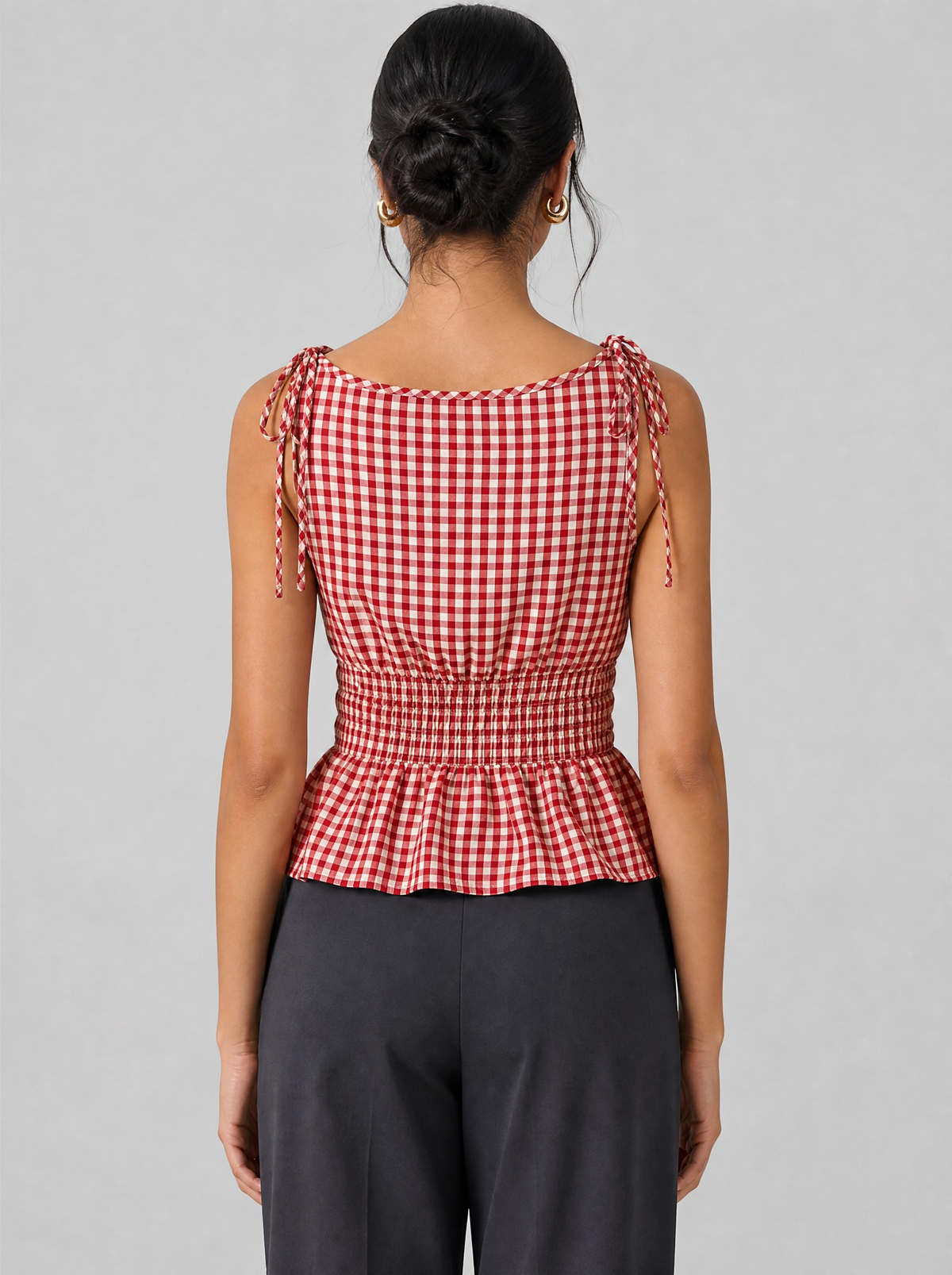 Back view of a red gingham peplum top showing the shoulder ties and shirred waist
