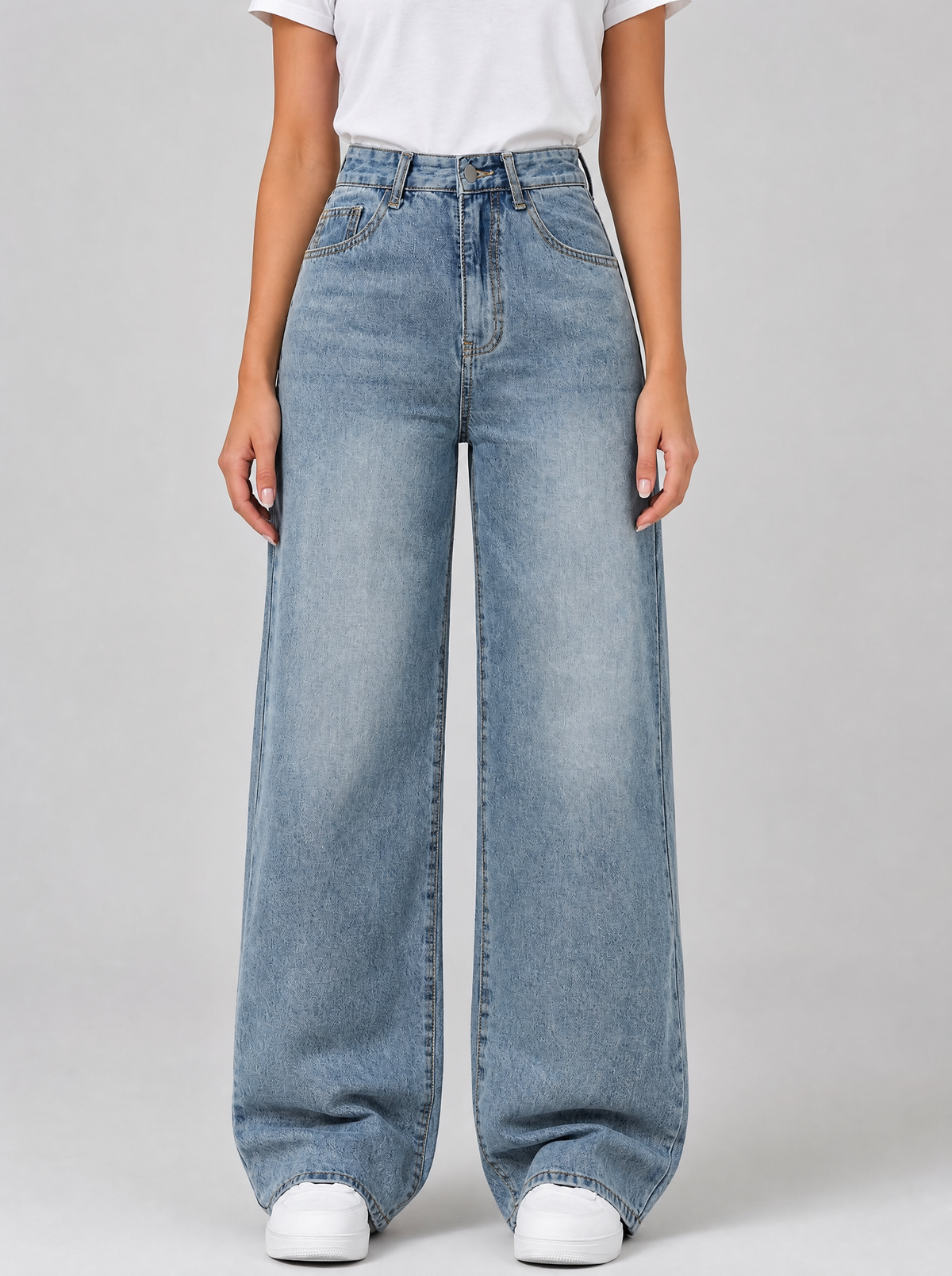 Woman wearing light wash high waist wide leg jeans, front view on a light grey studio background