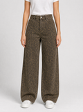 Woman wearing leopard print wide leg jeans, front view on a light grey studio background