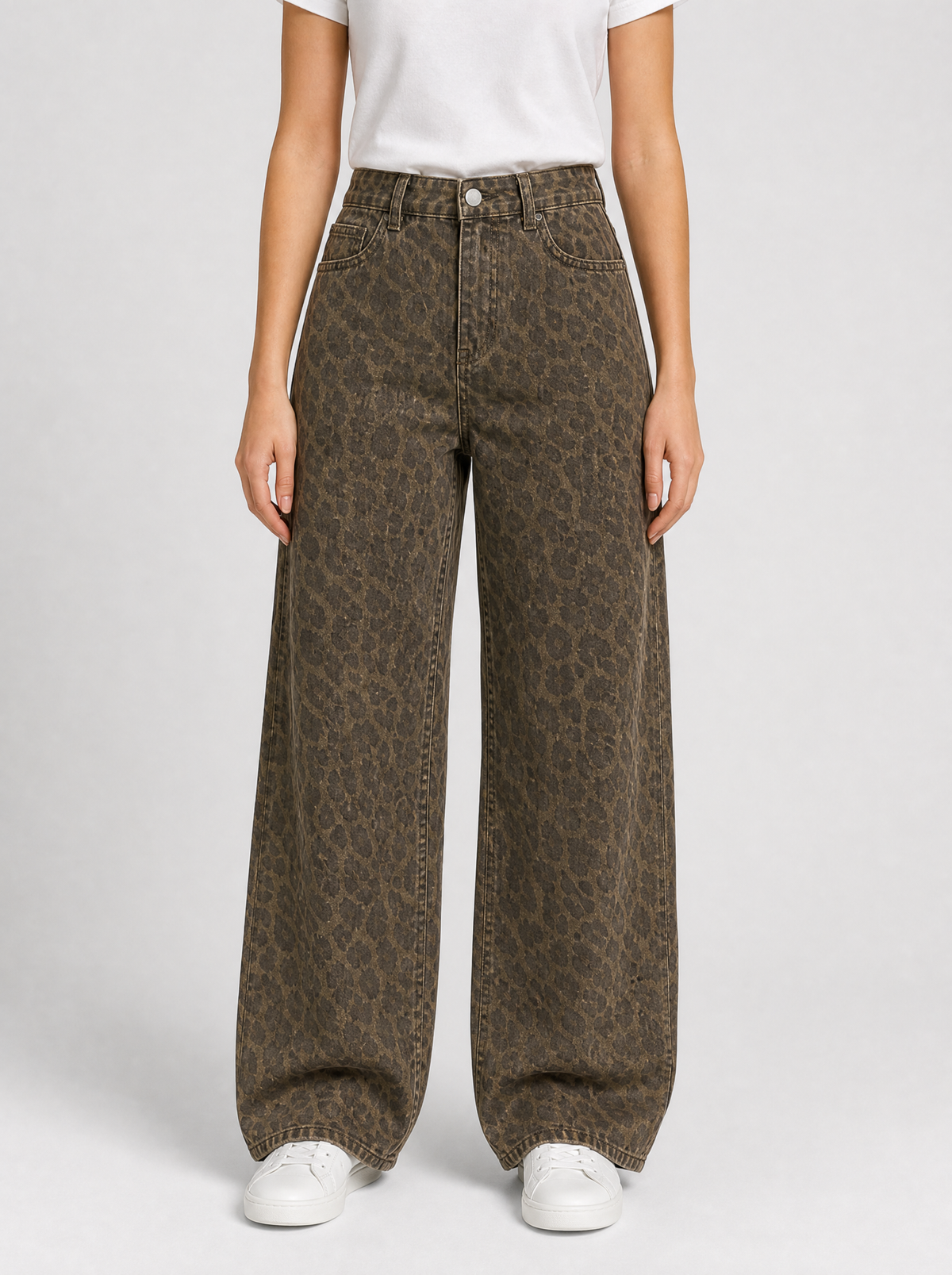 Woman wearing leopard print wide leg jeans, front view on a light grey studio background
