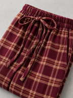 Close up of the drawstring waistband and plaid check weave on burgundy wide leg pants