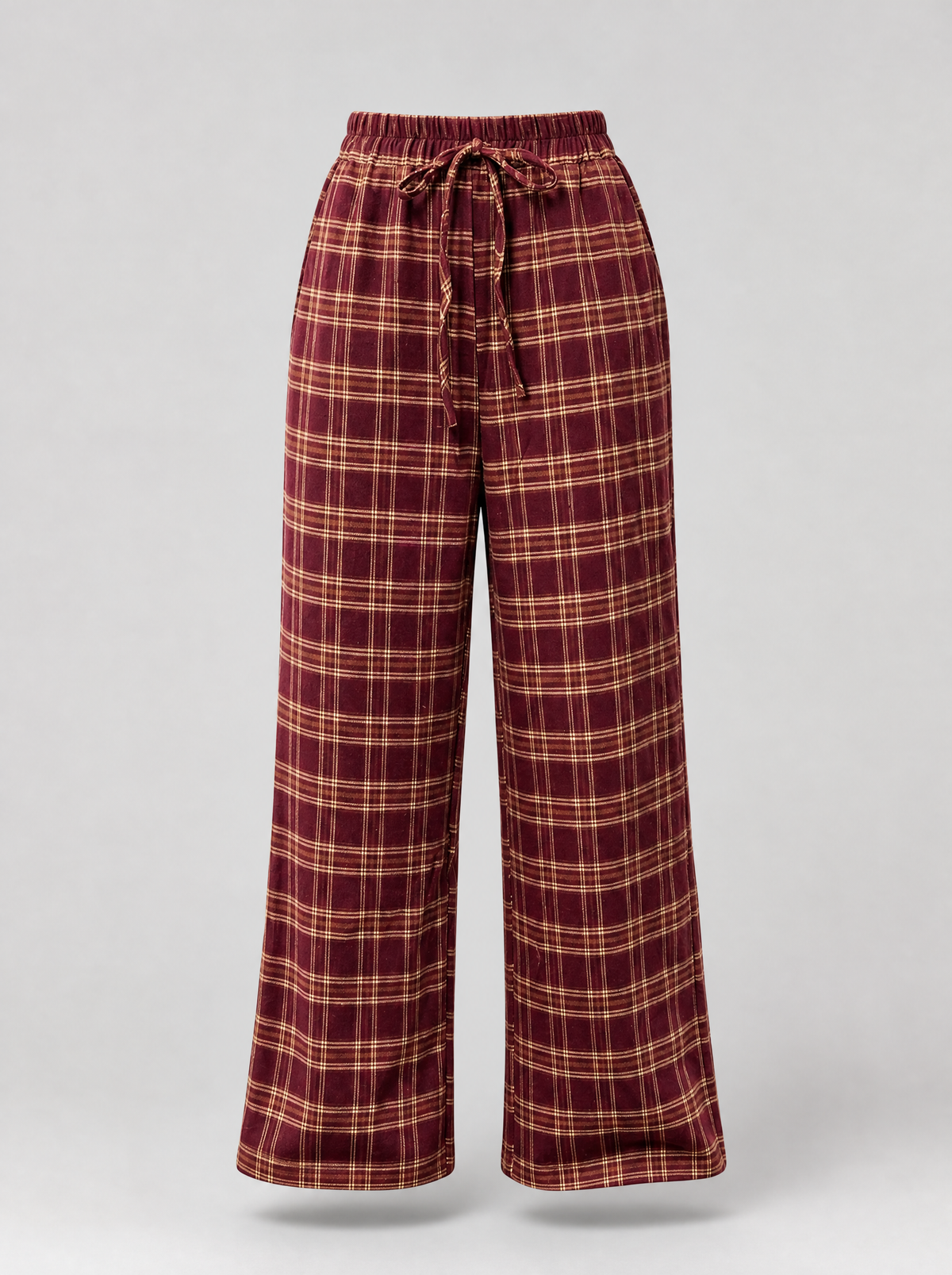 Burgundy plaid wide leg pants shown on their own against a light grey background