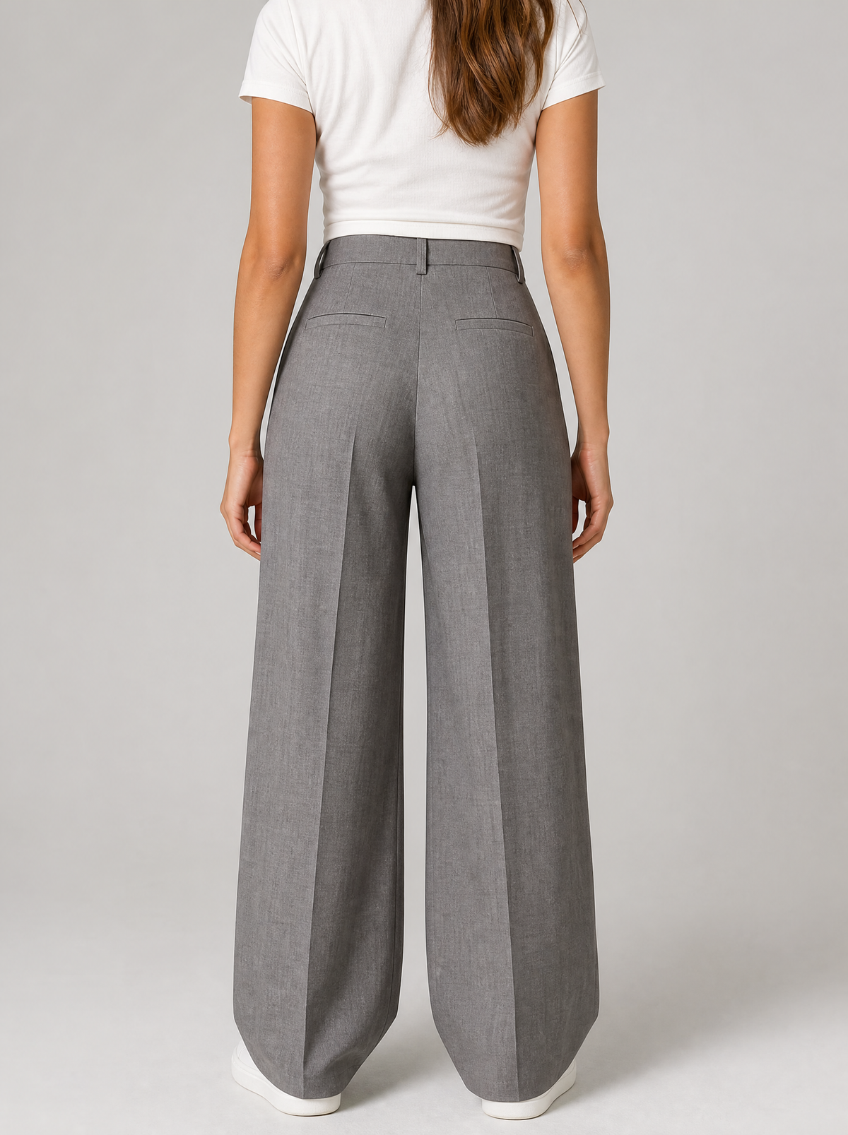 Back view of grey wide leg tailored trousers showing the waistband and back pockets
