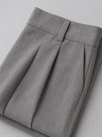 Close up of the waistband, belt loop and front pleat on grey tailored trousers