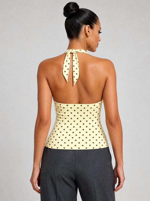 Back view of a yellow polka dot halter top showing the neck tie and open back