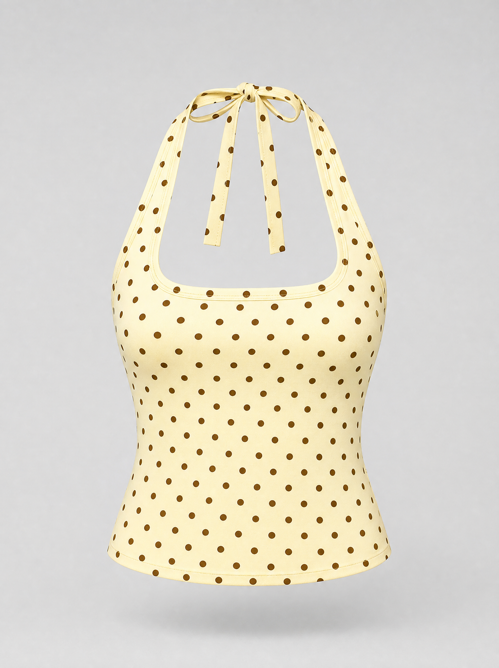 Yellow polka dot halter top shown on its own against a light grey background
