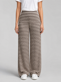 Woman wearing brown striped rib knit wide leg pants, front view on a light grey studio background