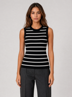 Woman wearing a black and white striped ribbed knit tank top, front view on a light grey studio background