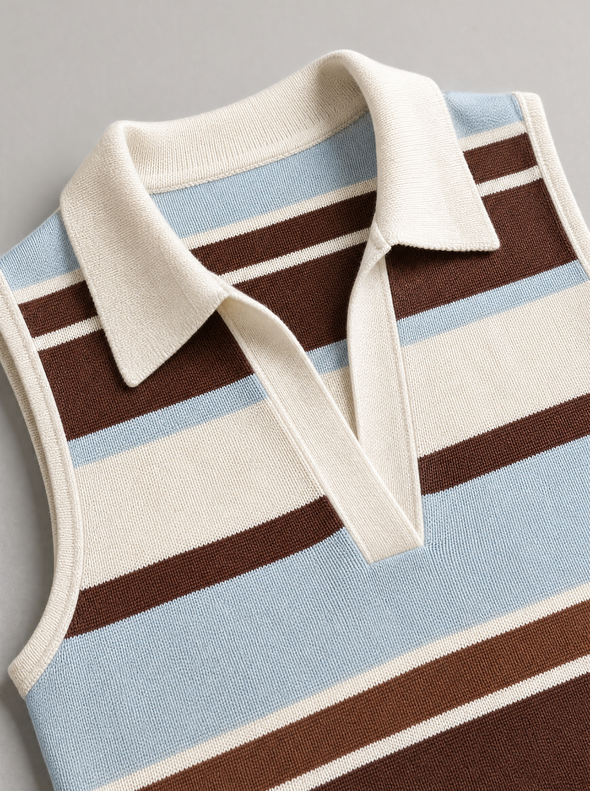 Close up of the knit collar and open placket on a striped sleeveless knit polo top
