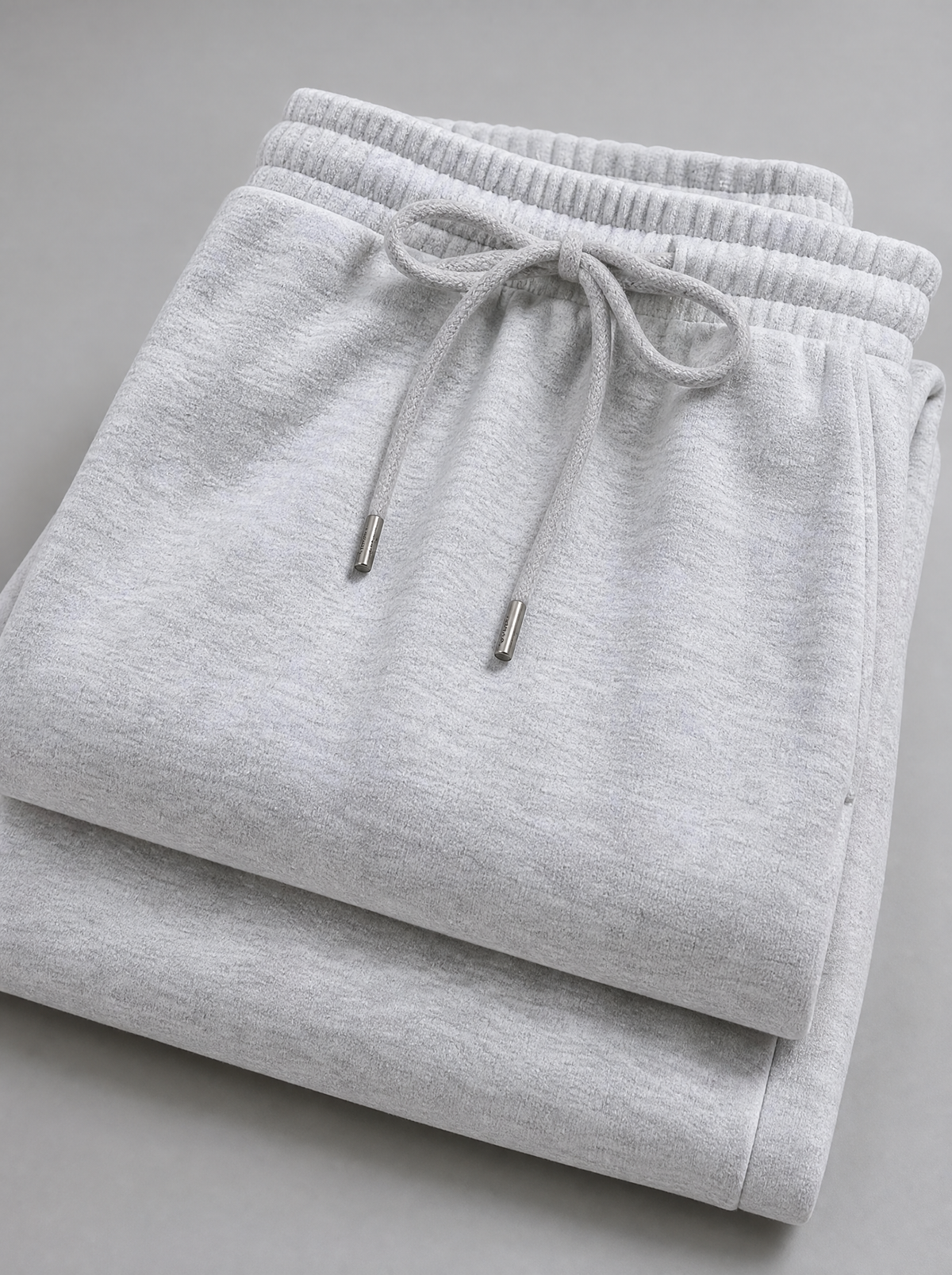 Close up of the drawstring waistband and brushed fleece on grey sweatpants