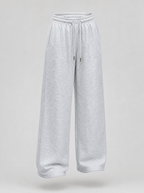 Grey wide leg fleece sweatpants shown on their own against a light grey background